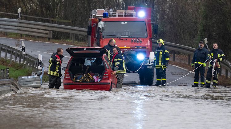 Trotz Hochwassersperre fuhren Autofahrer auf eine überschwemmte Straße bei Gießen. Ihre Autos wurden von der Freiwilligen Feuerwehr aus dem Wasser gezogen. 