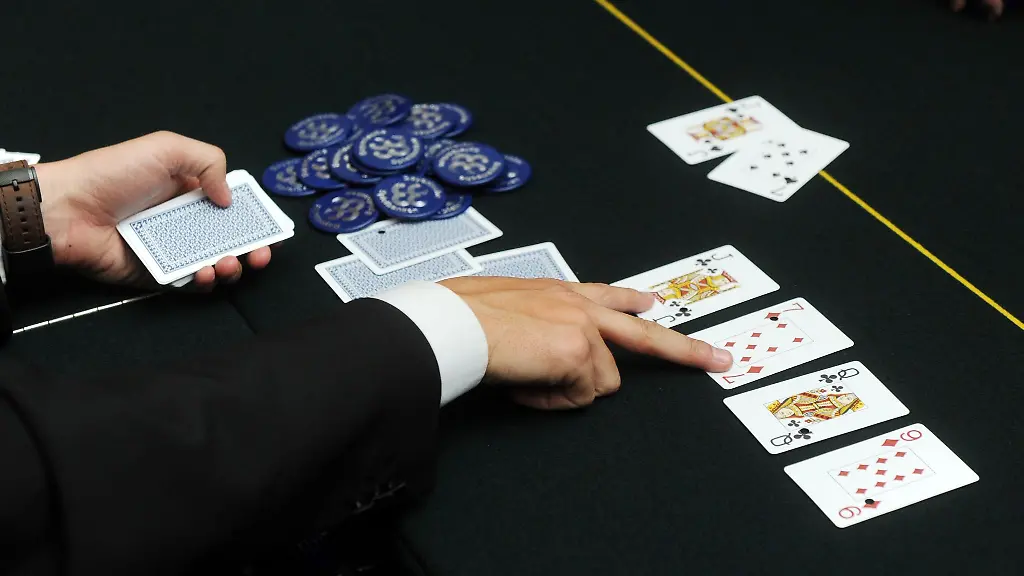 Der-Dealer-deutet-beim-Poker-auf-zwei-aufgedeckte-Karten