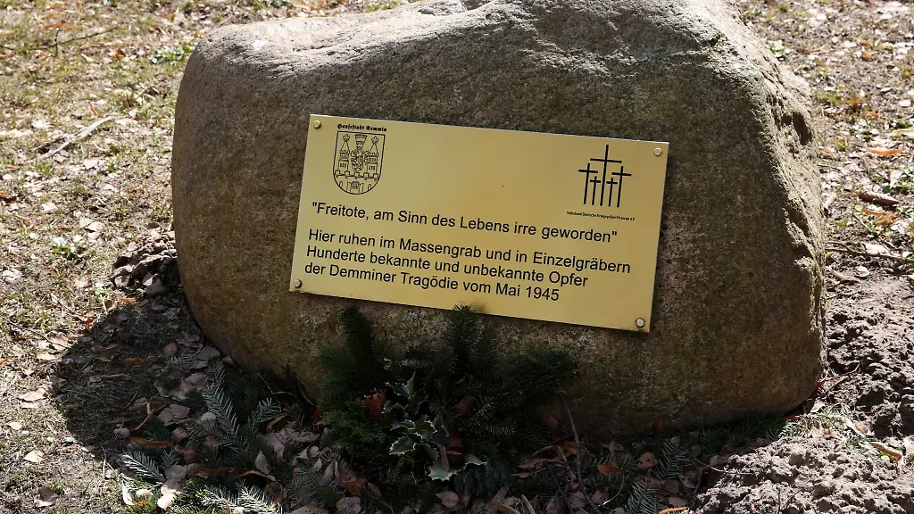 Eine-Tafel-an-einem-Gedenkstein-auf-dem-Friedhof-erinnert-an-den-Massenselbstmord-1945