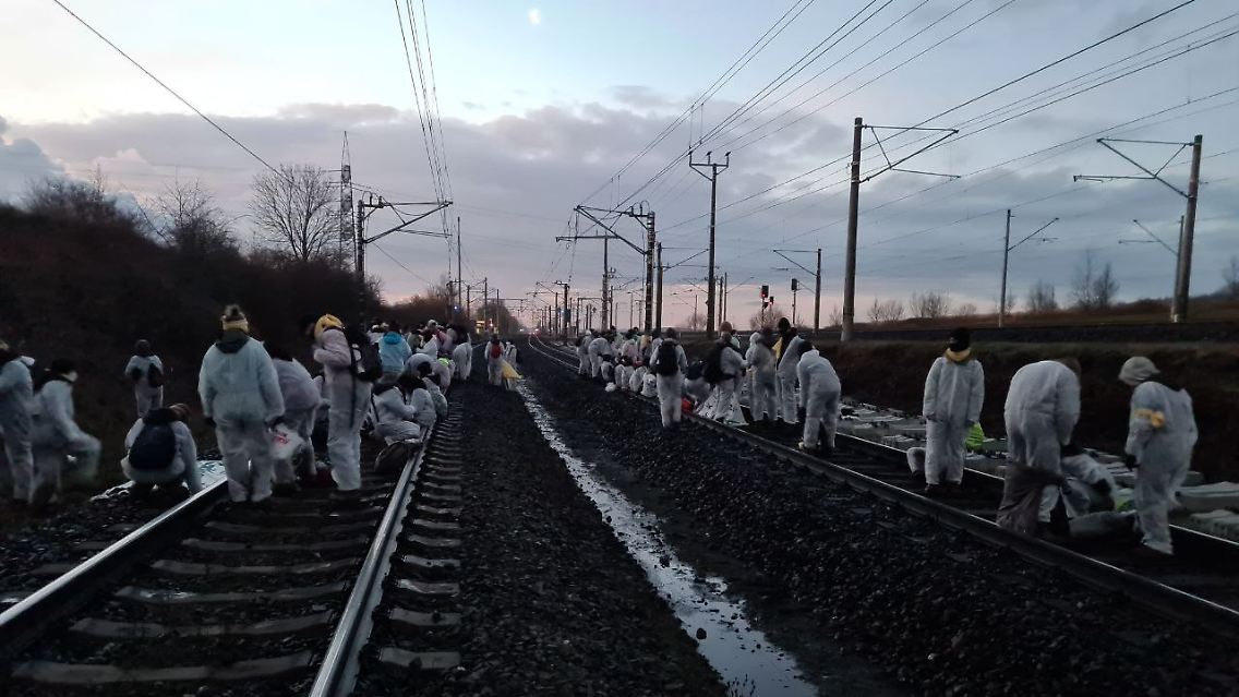 Menschen in weißen Anzügen bremsten die Werksbahn zum Kraftwerk Neurath aus.