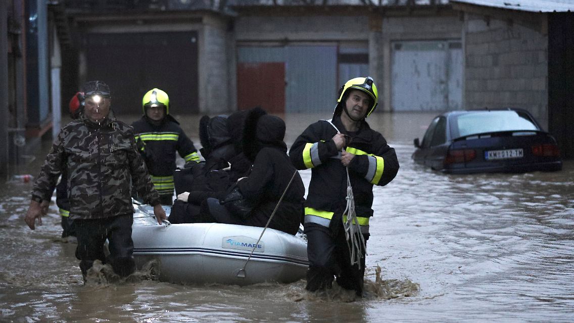 Feuerwehrleute evakuieren Menschen und ziehen sie per Schlauchboot durch das überflutete Mitrovica.