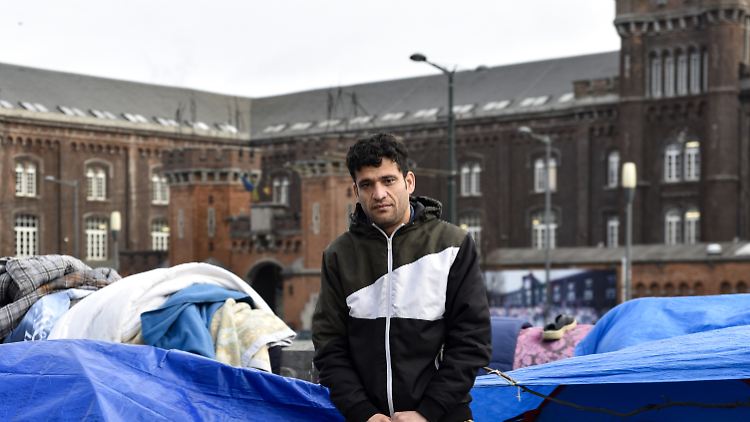 Faraidoon, ein afghanischer Asylbewerber, steht vor einem Zeltlager gegenüber dem Ankunftszentrum für Asylbewerber.