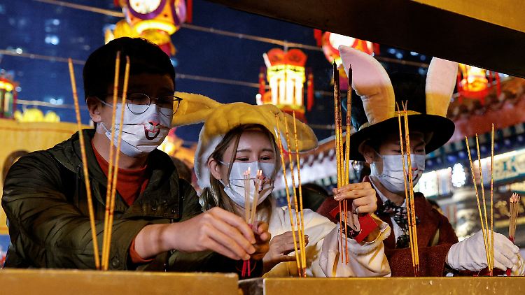 Neujahrsfeier mit Hasenkappe: Jugendliche in Hongkong zünden Räucherstäbchen an. 
