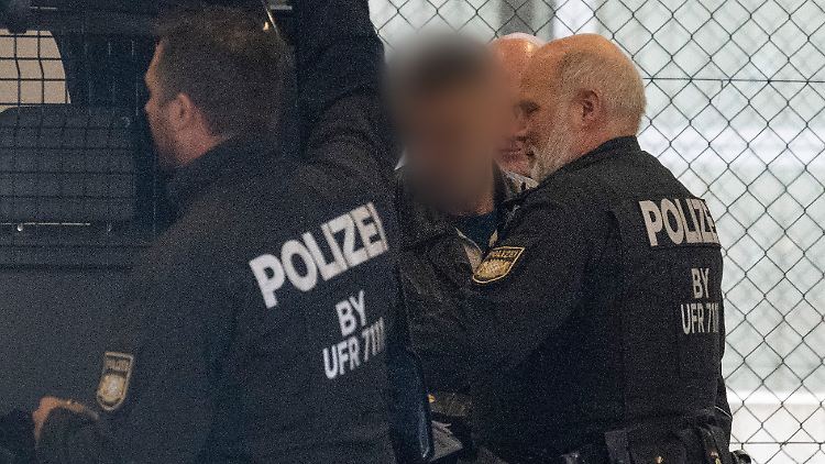Herisch A. wird am Frankfurter Flughafen von Polizisten zum Flugzeug eskortiert.