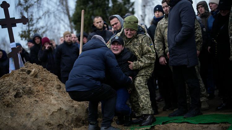 Eine Einwohnerin Bachmuts kniet während der Beerdigung vor dem Grab ihres Verlobten, einem ukrainischen Soldaten, der im Januar gefallen ist.