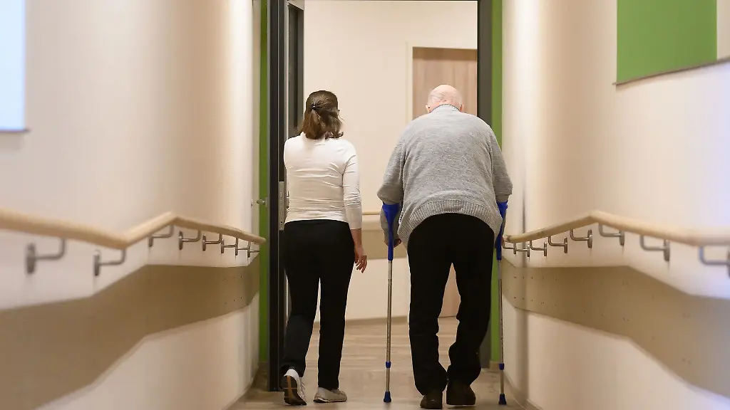 Ein-Patient-geht-mit-Kruecken-durch-einen-Flur