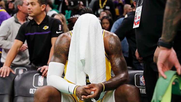 LeBron James verbirgt sein schmerzverzerrtes Gesicht unter einem Handtuch.