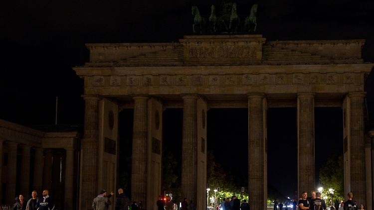 Das Brandenburger Tor in Berlin verschwindet fast in der Dunkelheit.
