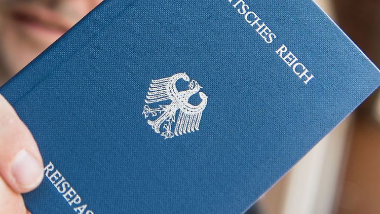 Ein Mann hält ein Heft mit dem Aufdruck "Deutsches Reich Reisepass" in der Hand. Sogenannte Reichsbürger leugnen die Existenz der Bundesrepublik Deutschland.