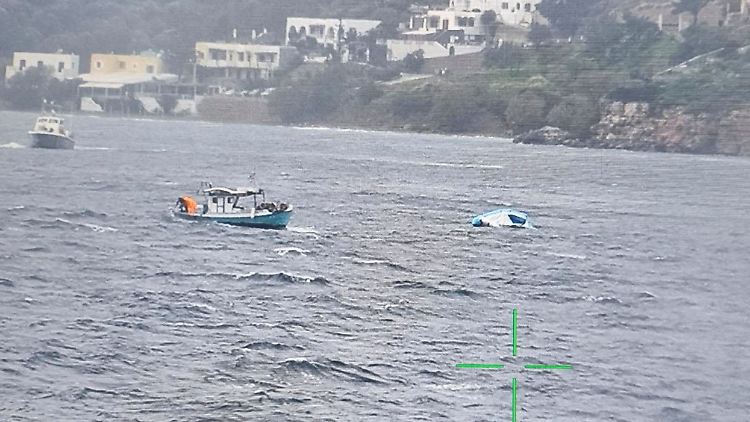 Ein Fischerboot nähert sich dem halb gesunkenen Schlauchboot, das Migranten vor der Insel Leros  transportierte.