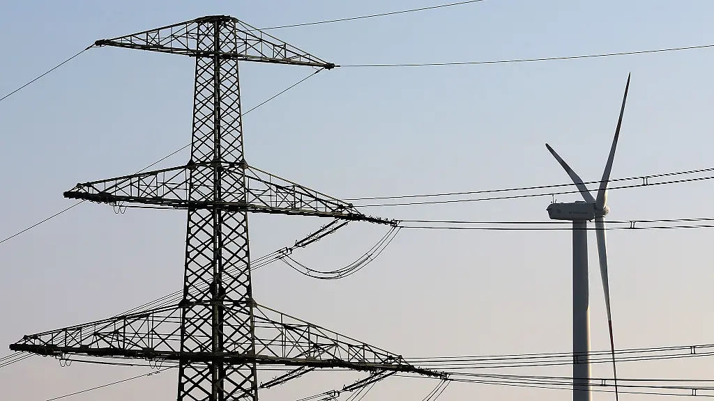 Ein-Windrad-dreht-sich-in-der-Naehe-von-Hochspannungsleitungen