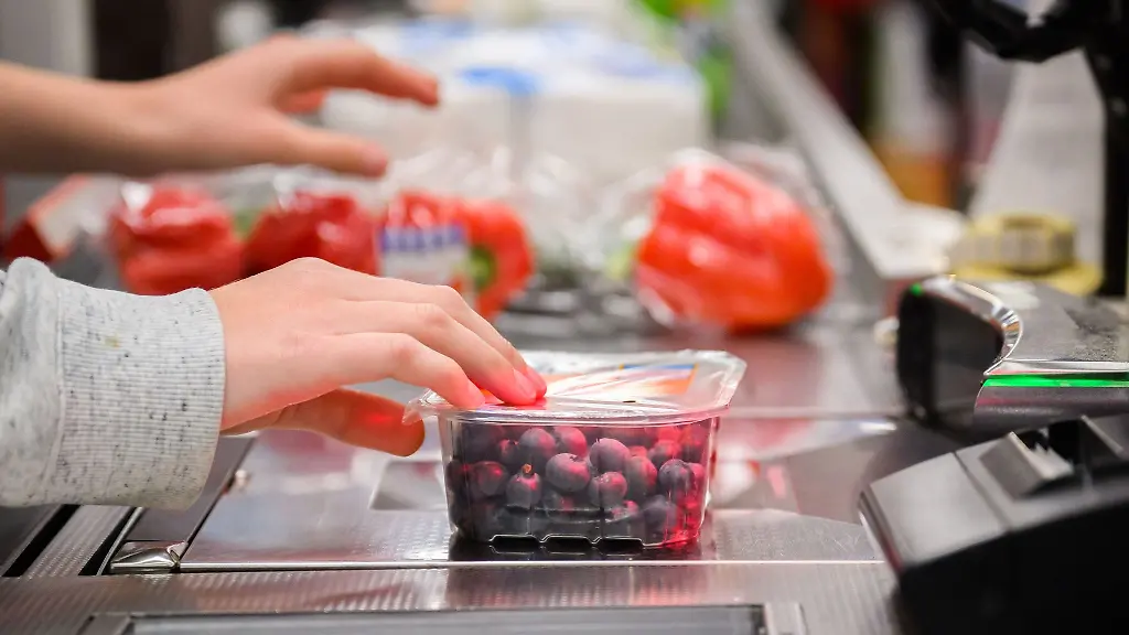 Eine-Kassiererin-scannt-Heidelbeeren-an-der-Kasse-eines-Supermarktes