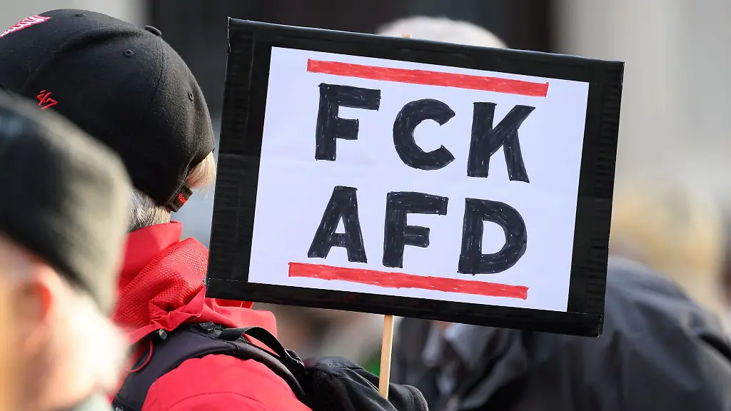 Ein-Teilnehmer-einer-Demonstration-vom-Aktionsbuendnis-Pirna-ist-bunt-unter-dem-Motto-Alle-zusammen-fuer-Solidaritaet-und-Offenheit-steht-mit-eine-Schild-FCK-AFD-auf-dem-Marktplatz