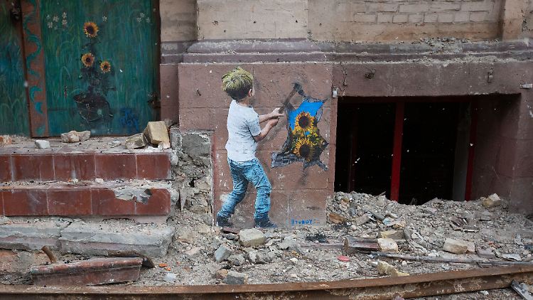 Ein Kunstwerk des italienischen Straßenkünstlers TVBOY mit den Botschaften von Hoffnung und Frieden im Zentrum der Stadt Butscha.