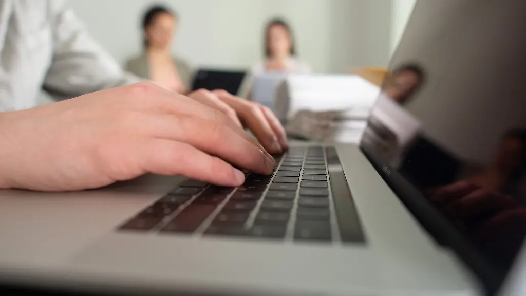 Ein-Mann-tippt-einem-Buero-auf-einer-Tastatur-eines-Laptops