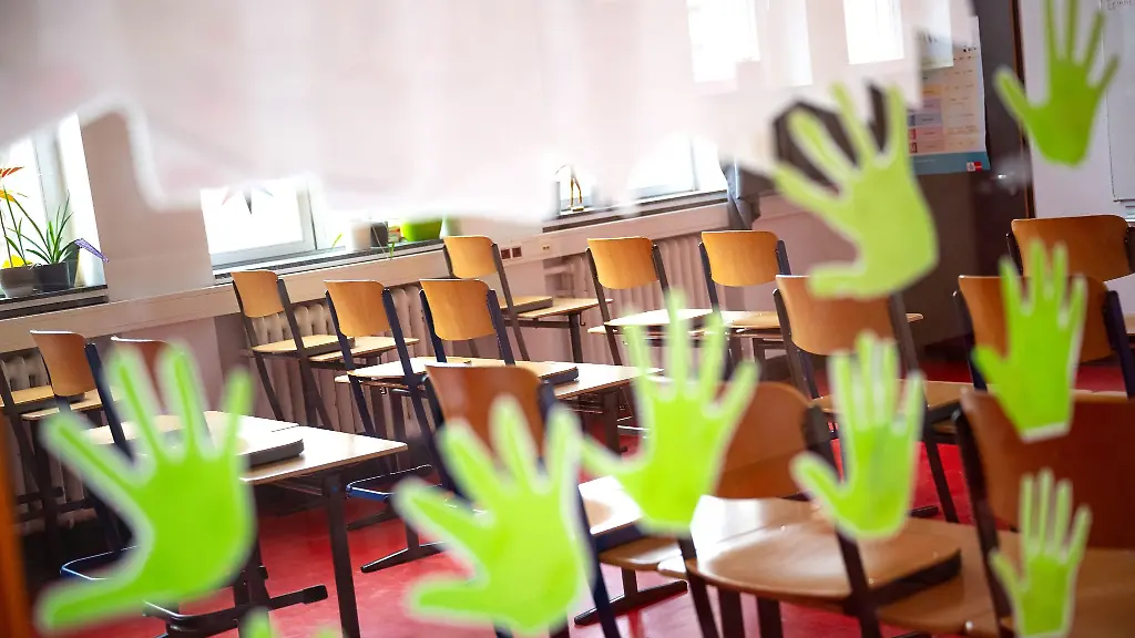 Aus-Papier-ausgeschnittene-Haende-haengen-an-einem-Fenster-zu-einem-Klassenraum-in-Bremen