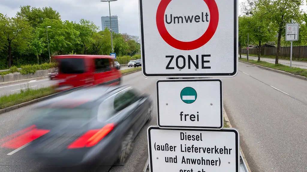 Strassenschilder-mit-der-Aufschrift-Umwelt-Zone-und-Diesel-ausser-Lieferverkehr-und-Anwohner-erst-ab-Euro-5-V-frei-haengen-zwischen-den-Strassen-am-Muenchner-Ring