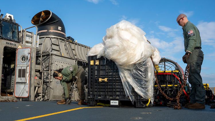 US-Matrosen bereiten die Reste des chinesischen Ballons, der von der US-Luftwaffe über dem Atlantik abgeschossen worden war, für den Transport vor.