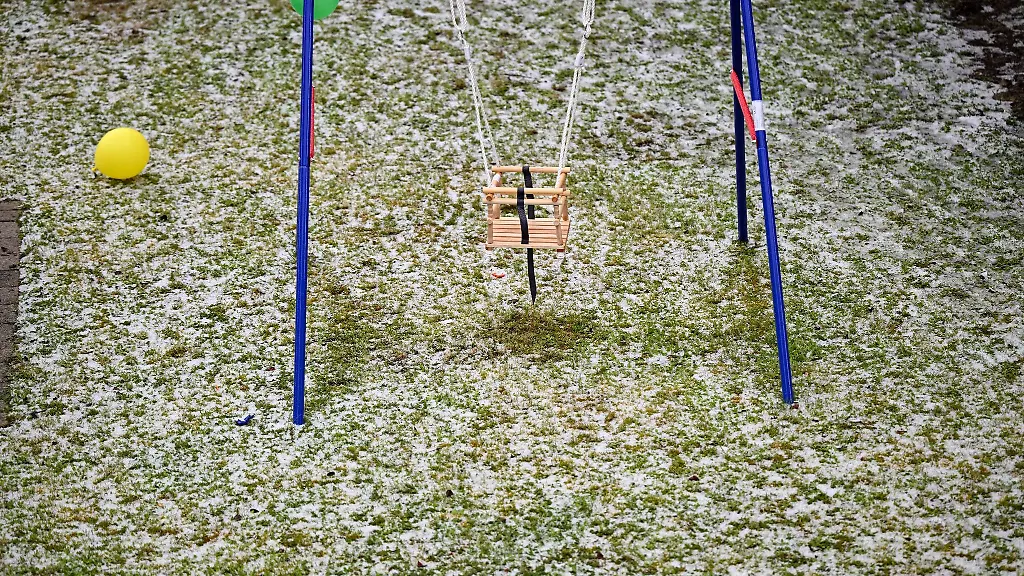 Nach-einem-heftigen-Graupelschauer-ist-der-Rasen-mit-weissen-gefrorenen-Kuegelchen-ueberzogen