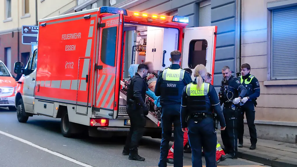 Ein-Mann-wird-auf-einer-Liege-in-einen-Krankenwagen-geschoben