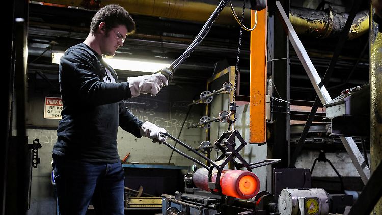 Ein Arbeiter inspiziert eine glühende 155-mm-Artilleriegranate in einer amerikanischen Militärfabrik.