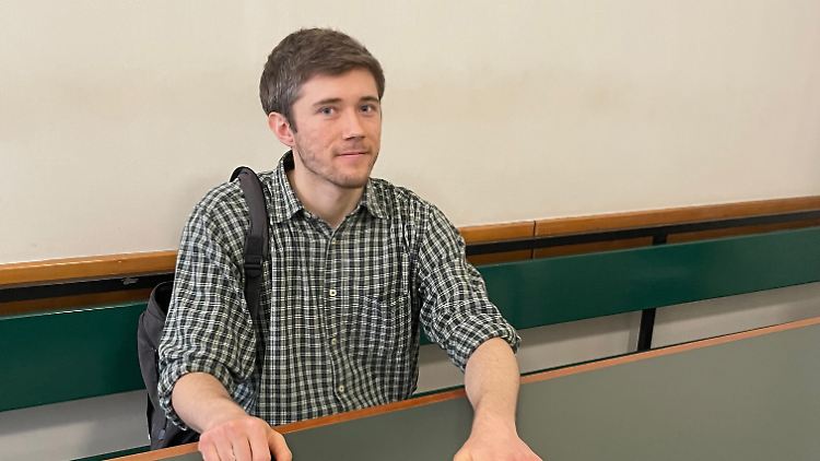 Klimaaktivist Henning Jeschke festgeklebt an einem Tisch in einem Raum des Amtsgerichts Berlin Tiergarten.
