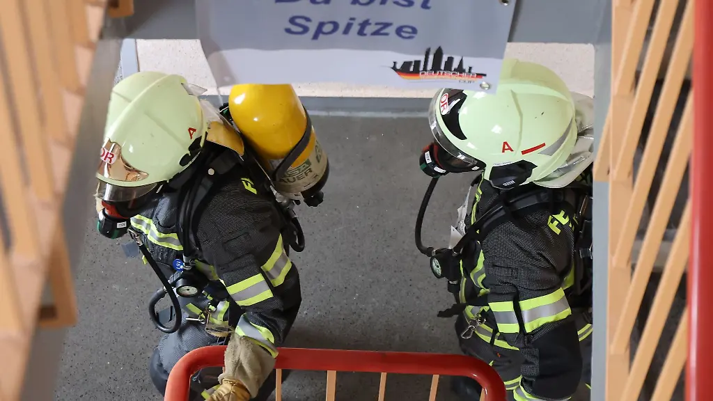 Feuerwehrmaenner-mit-Atemschutzmaske-und-Sauerstoffflasche-rennen-eine-Treppe-hoch-beim-10-Zwickauer-Hochhaus-Treppenlauf-und-5-Feuerwehr-Treppenlauf