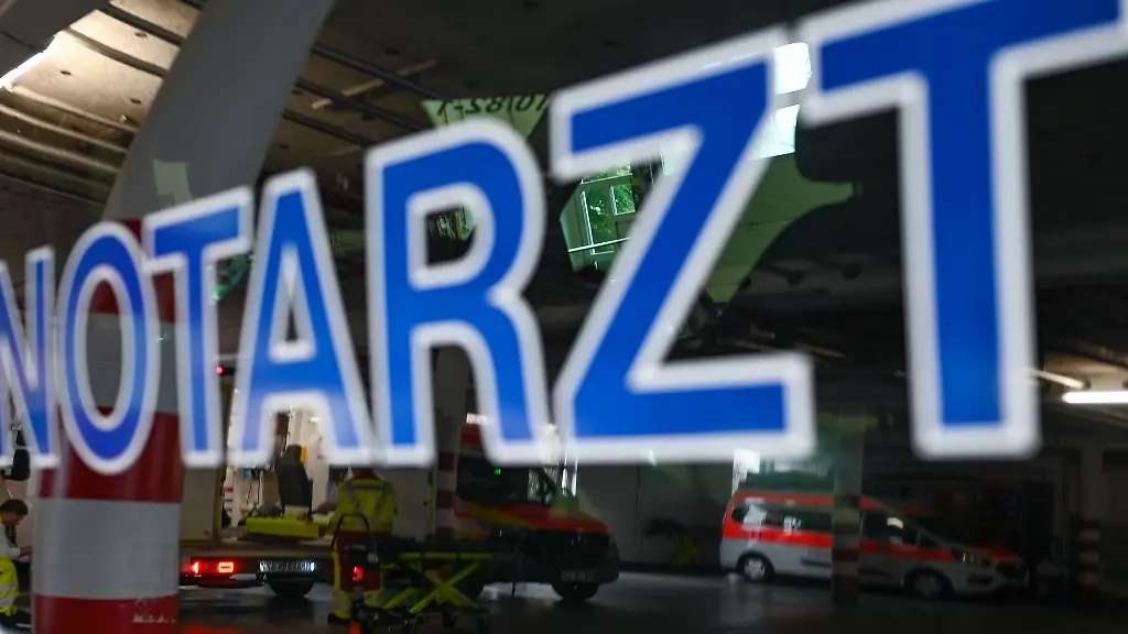 In-der-Fensterscheibe-eines-Notarztfahrzeugs-des-DRK-Kreisverbands-Gelnhausen-Schluechtern-spiegelt-sich-die-Fahrzeughalle