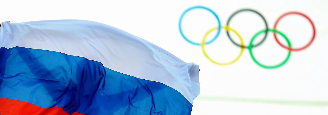 Ein Athlet aus Russland feiert mit einer Flagge nach einem Event bei den Olympischen Spielen 2014.