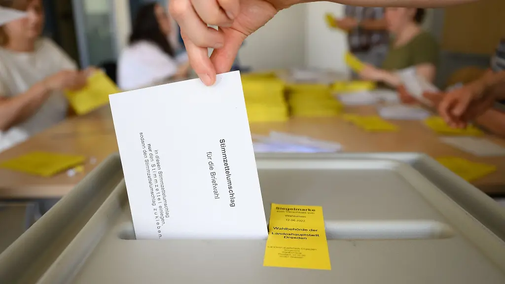 Ein-Stimmzettelumschlag-fuer-die-Briefwahl-zur-Oberbuergermeisterwahl-wird-nach-der-der-Pruefung-der-Gueltigkeit-aller-Unterlagen-im-Briefwahlzentrum-im-Gymnasium-Buergerwiese-in-eine-Wahlurne-geworfen-Die-Stadt-Dresden-sucht-weiterhin-nach-Wahlhelferinnen-und-Wahlhelfer