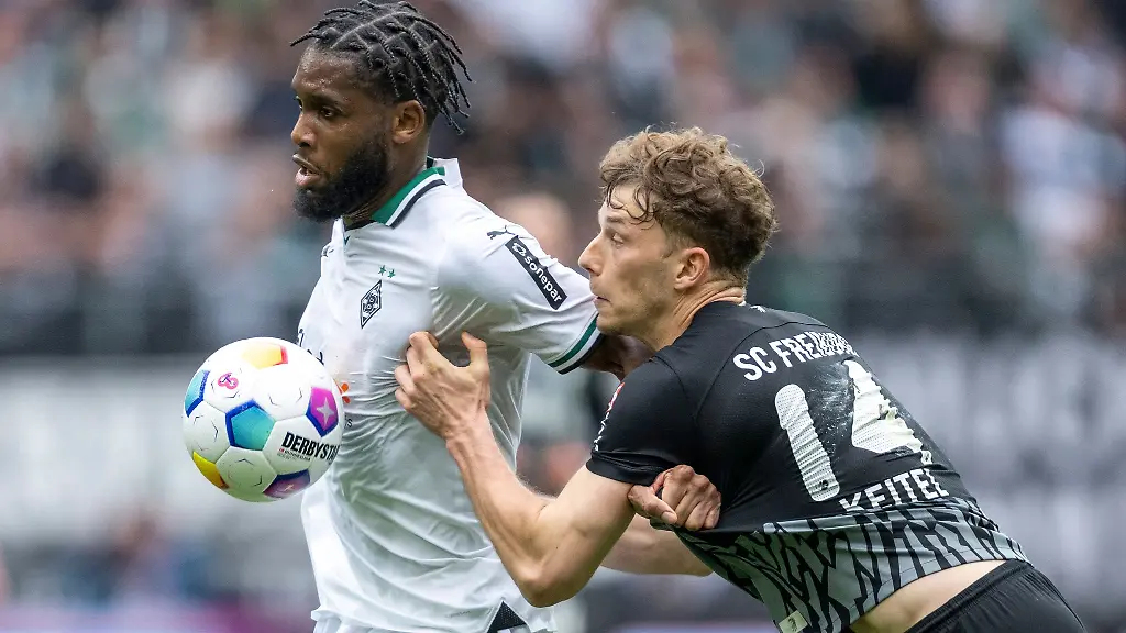 Gladbachs-Jordan-Siebatcheu-l-und-Freiburgs-Yannik-Keitel-kaempfen-um-den-Ball-Siebatcheu-faellt-am-Wochenende-aus