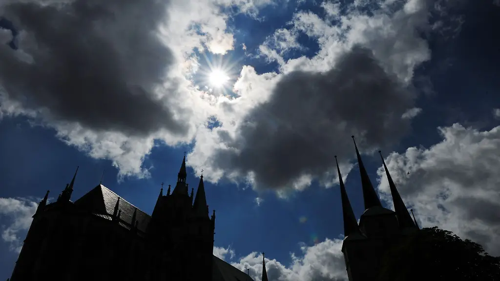 Die-Sonne-strahlt-zwischen-den-Wolken-ueber-den-Tuermen-des-Erfurter-Doms-und-der-Severikirche