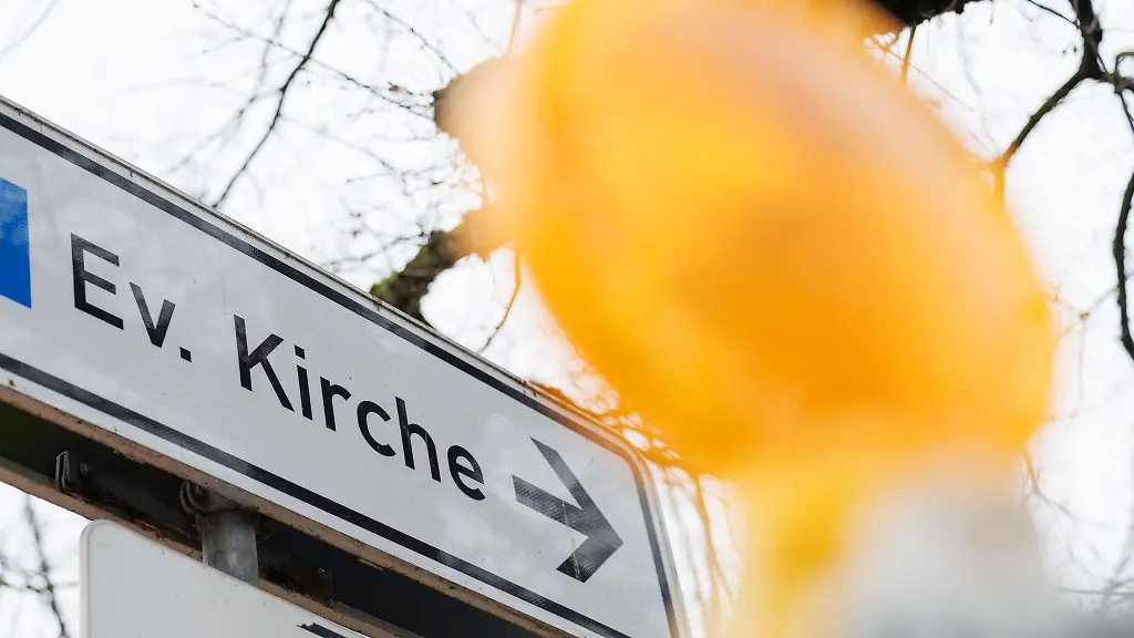 Blick-auf-ein-Verkehrsschild-mit-der-Aufschrift-Ev-Kirche