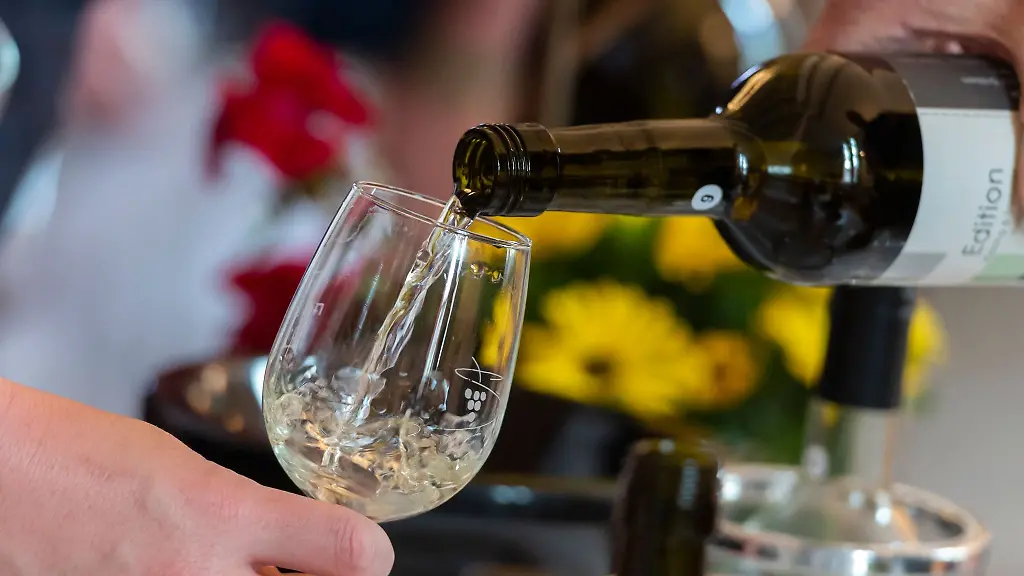 Ein-Weinglas-wird-mit-Weisswein-befuellt