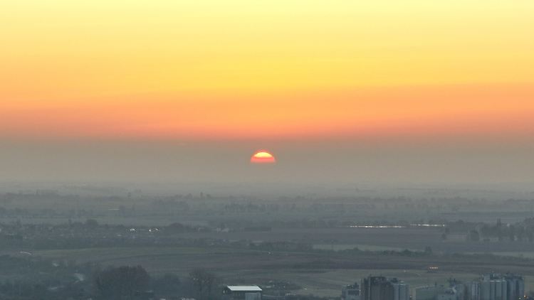 Man sieht die Sonne am Morgen bereits am Himmel, obwohl sie noch unterhalb des Horizonts liegt - Grund ist die Lichtbrechung in der Atmosphäre.