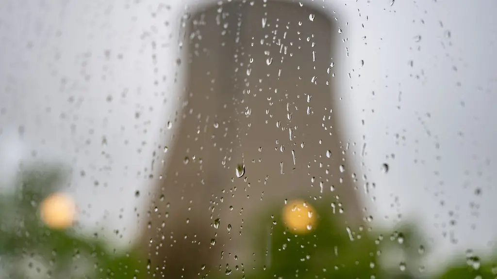 Der-Kuehlturm-des-stillgelegte-Kernkraftwerks-Isar-2-hinter-einer-Fensterscheibe-mit-Regentropfen