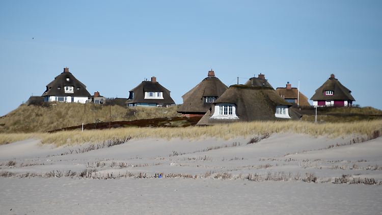Typische Sylter Reetdachhäuser hinter dem Strand von Hörnum.