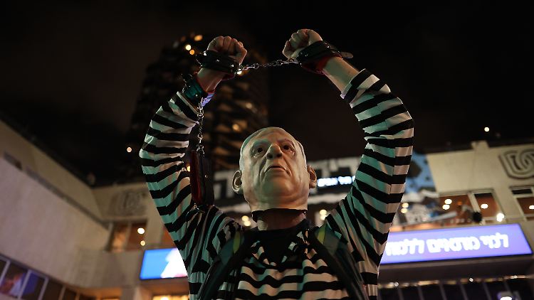 Massendemonstration in Tel Aviv: Ein Protestler ist als Netanjahu in Häftlingskleidung maskiert.