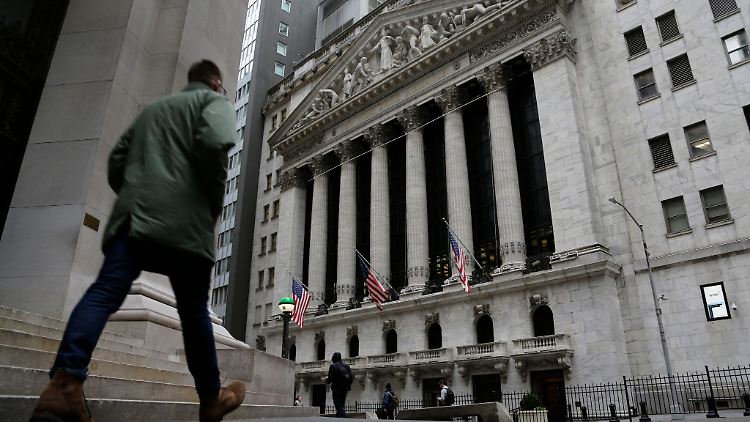 Menschen passieren die Fassade der New Yorker Börse.