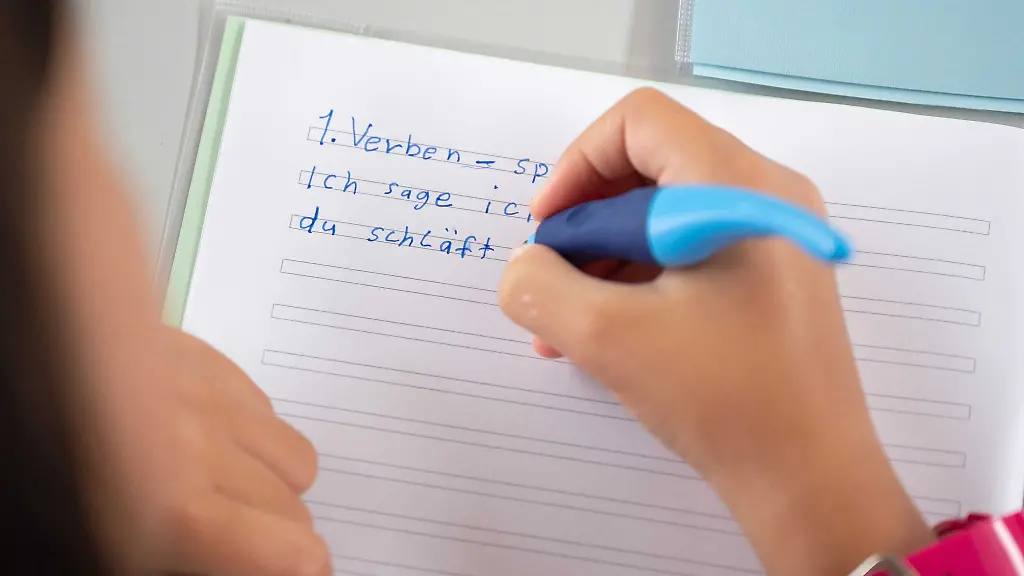 Eine-Schuelerin-einer-Grundschule-soll-konjugiert-Verben-in-ihr-Heft-schreiben