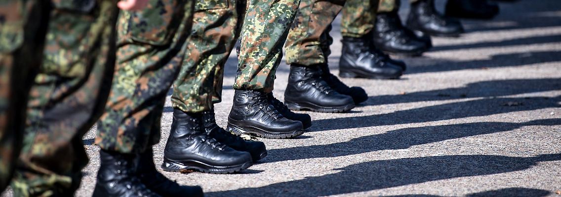 Bundeswehrsoldaten stehen auf einem Platz.
