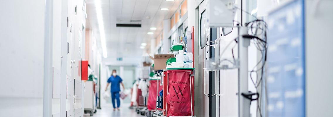 Eine Pflegekraft geht auf einer Intensivstation über den Flur.