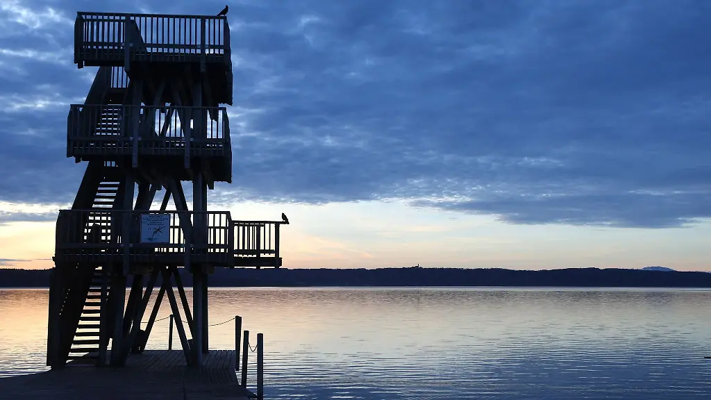 Im-Sonnenaufgang-steht-der-hoelzerne-Sprungturm-des-Strandbades-am-Ammersee