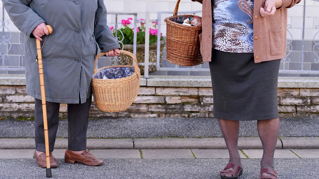 Zwei-aeltere-Dame-tragen-nach-einem-Einkauf-im-mobilen-Einkaufsladen-in-Hassenberg-Bayern-ihre-Lebensmittel-nach-Hause