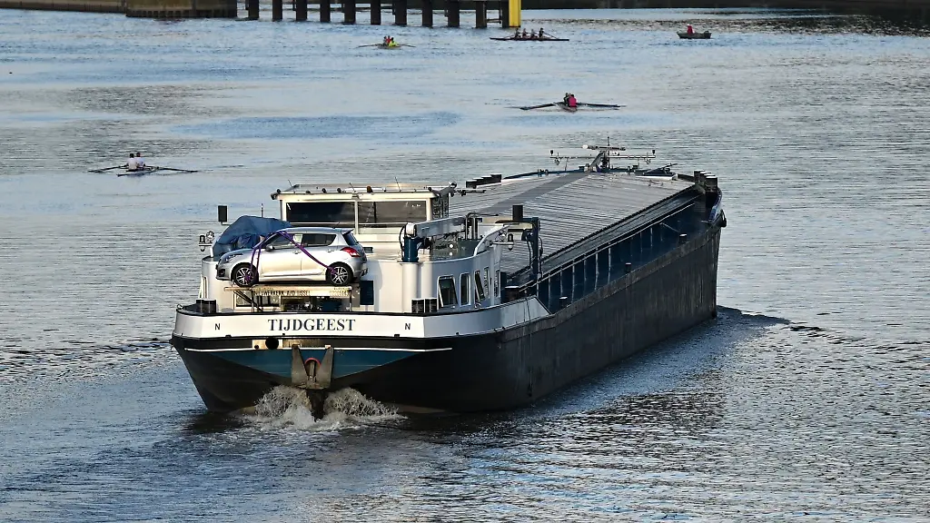 Waehrend-ein-Frachtschiff-Richtung-Schleuse-faehrt-sind-Ruderboote-auf-dem-Main-unterwegs