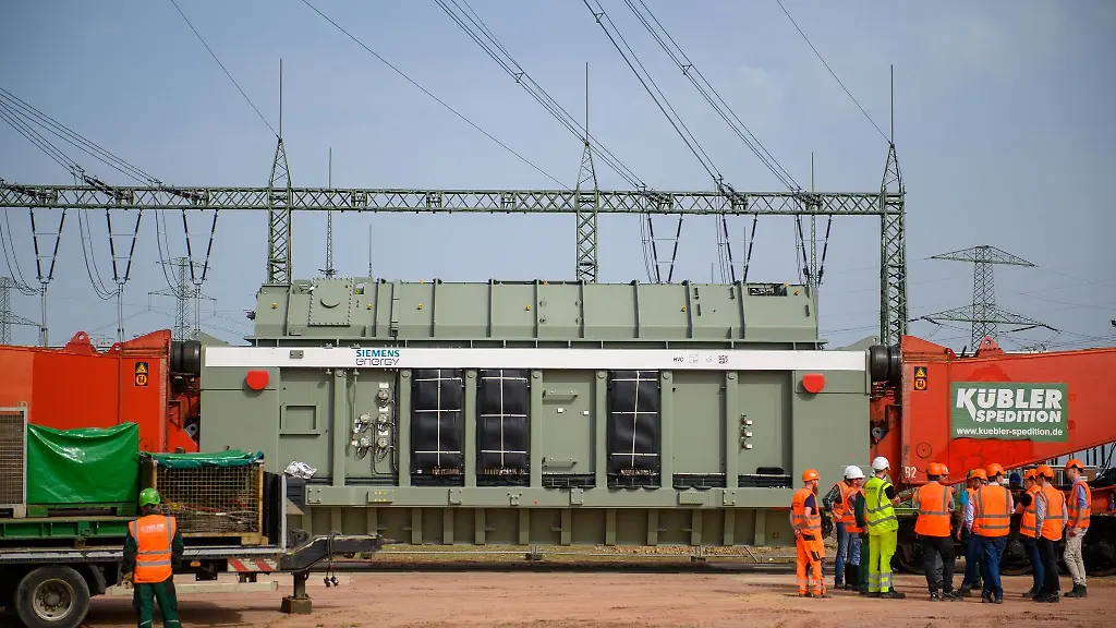 Techniker-und-Ingenieure-stehen-im-Umspannwerk-Wolmirstedt-vor-einem-Transformator-und-beraten-sich