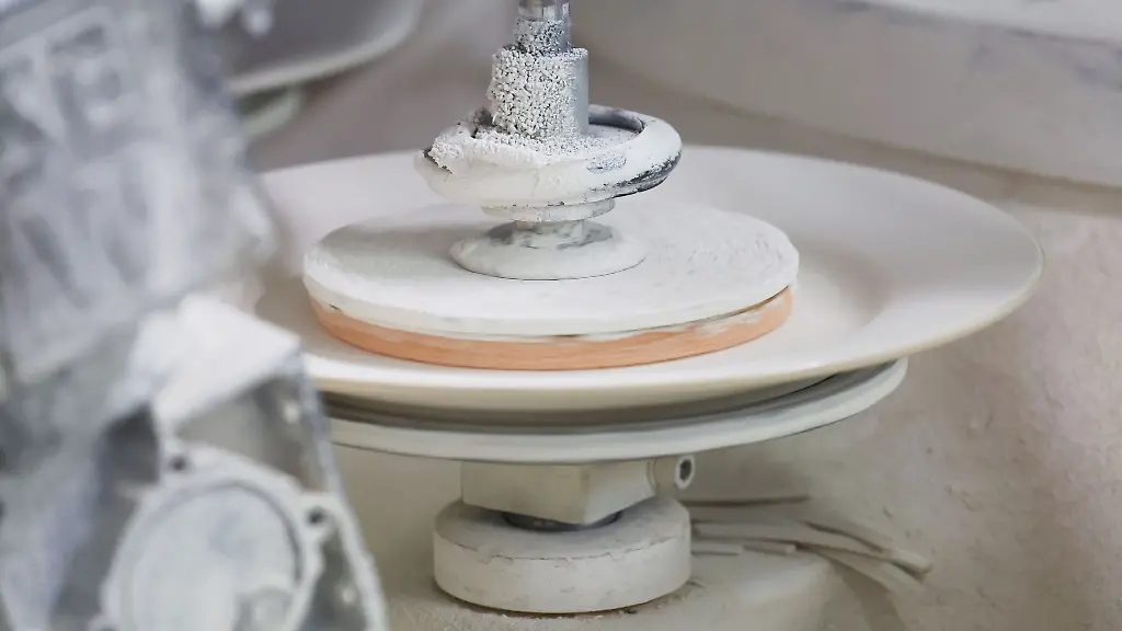 Ein-Teller-wird-in-der-Porzellanmanufaktur-Kahla-von-einer-Maschine-bearbeitet