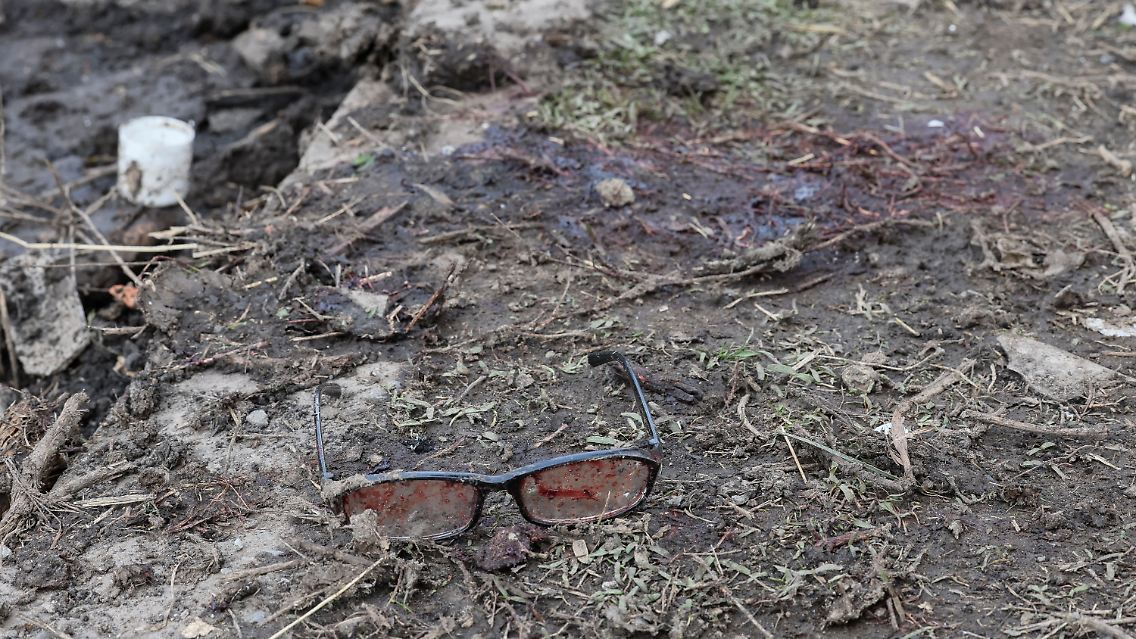 Eine Brille mit Blut, sowie Blut auf dem Boden.