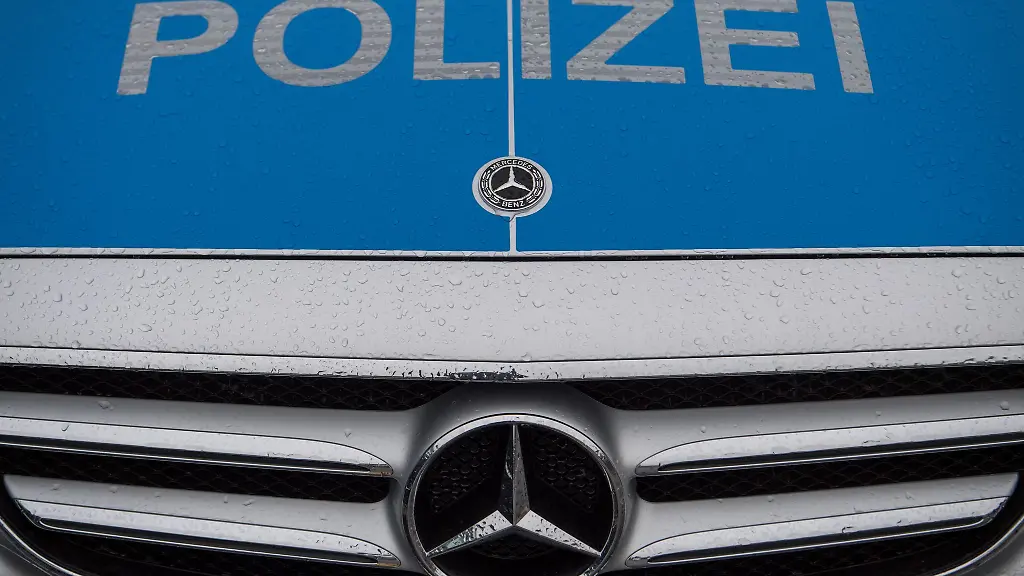 Polizei-steht-auf-der-Motorhaube-eines-Polizeiautos
