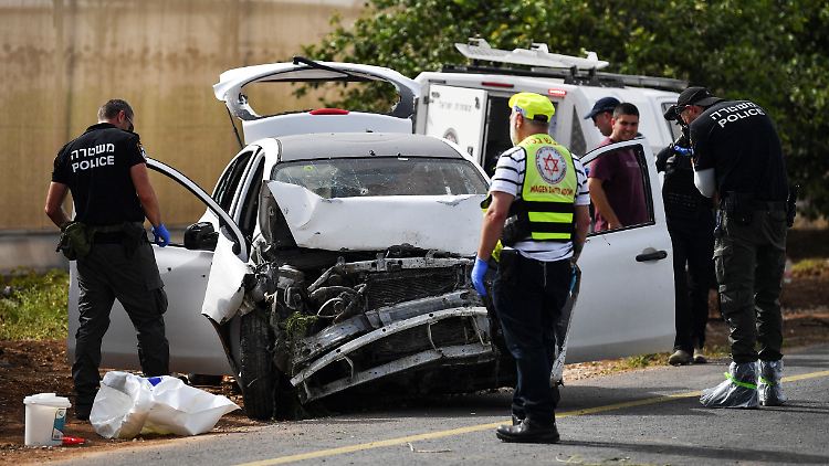 Polizei und Rettungskräfte untersuchen das Auto, in dem die Frauen starben.